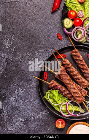 Traditional middle eastern, arabic or mediterranean meat kebab with vegetables and pita bread. Top view. Stock Photo