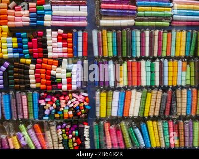 Shelves Of Textile Store That Sells Multi-Colored Satin Ribbons. Concept Of Needlework And Home Tailoring, Handmade Sewing. Textile industry. Stock Photo