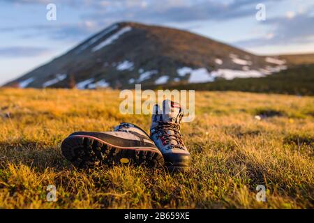 Old trekking boots on background volcano Stock Photo