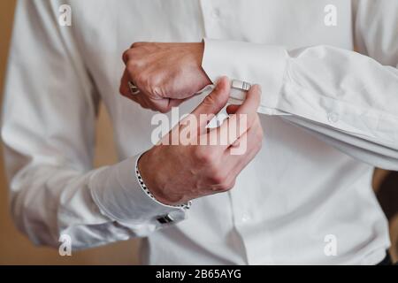 man in white shirt near window dress cufflinks. Stock Photo
