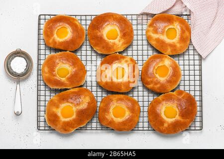 Fresh baked easter bread rolls with apricot on cake cooling rack  for breakfast. Top view. Homemade sweet food concept. Stock Photo