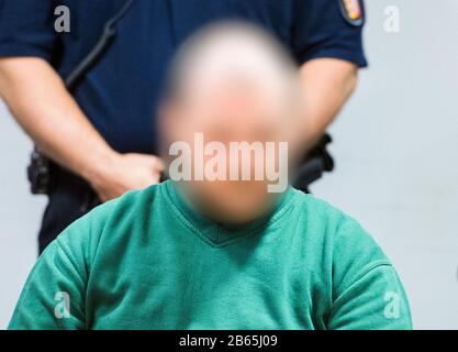 10 March 2020, Schleswig-Holstein, Lübeck: An accused prisoner sits in the regional court in the hall. The man is alleged to have taken a psychologist hostage and threatened her with a knife in June 2019 in the Lübeck prison in order to force his deportation to Romania. (to dpa 'Trial against suspected hostage-takers from Lübeck prison begins') Photo: Daniel Bockwoldt/dpa - ATTENTION: The defendant was pixelated for legal reasons Stock Photo