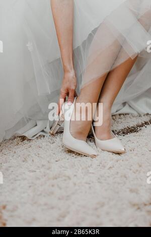 3 women put their feet on a young boy on a dance floor at a wedding ...