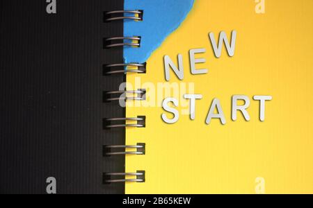 New start - words made of silver paper letters put on open copybook, starting new life new chapter concept Stock Photo