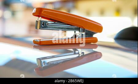 Close up of the orange stapler on the table Stock Photo