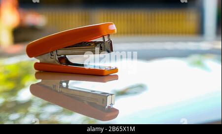 Close up of the orange stapler on the table Stock Photo