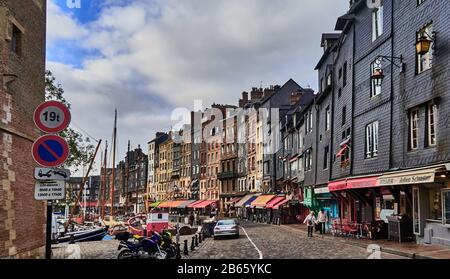 France, Normandie , Honfleur city, This is a popular resort town for both the French and foreigners. Originally a fishing village, it is now a tourist destination, on the cobblestones of Sainte Catherine quai on the left side of the street is the mooring area in the inner harbor for pleasure craft and sailboats. The right sidethe right side is lined with houses and sidewalk cafes on the ground level.. Stock Photo