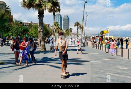 BARCELONA, SPAIN - MAY 30: People walking and skatebording in the seafront of La Barceloneta on May 30, 2016 in Barcelona, Spain. The city has a long Stock Photo