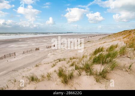 The beach and North Sea on a stormy but sunny day at the Maaslvakte near Rotterdam in the Netherlands. Ships arriving at the Port of Rotterdam in the Stock Photo