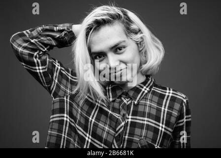 Young Asian man wearing stylish clothes against gray background Stock Photo