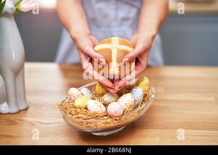 Happy adult woman preparing hot cross buns for Easter in the kitchen Stock Photo