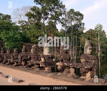 Archeological site ,The South Gate of Angkor Thom leads to Bayon Temple. Lined with 54 stone figures engaged in a performance of a famous Hindu story, it extends about 50 metres across a moat. Stock Photo