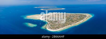 Panoramic aerial drone view of beautiful tropical islands surrounded by coral reef. (Gili Islands, Indonesia) Stock Photo