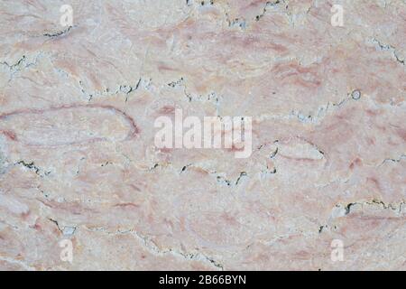 Close-up of an old, weathered, cracked and colorful marble stone wall. Looks also like meat. High resolution full frame textured background. Stock Photo
