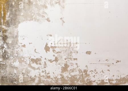 Close-up of a weathered, old&moldy concrete wall, plastering painted in white has peeled off. High resolution abstract full frame textured background. Stock Photo