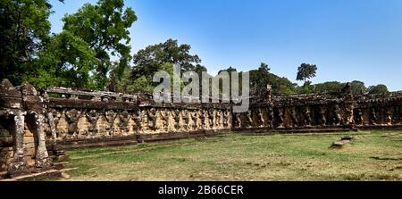 The Leper King's Terrace is part of the walled city of Angkor Thom, a ruined temple complex in Cambodia. The terrace was used by Angkor's king Jayavarman VII as a platform from which to view his victorious returning army. It was attached to the palace of Phimeanakas, of which only a few ruins remain. Most of the original structure was made of organic material and has long since disappeared. Stock Photo