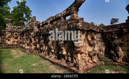 The Leper King's Terrace is part of the walled city of Angkor Thom, a ruined temple complex in Cambodia. The terrace was used by Angkor's king Jayavarman VII as a platform from which to view his victorious returning army. It was attached to the palace of Phimeanakas, of which only a few ruins remain. Most of the original structure was made of organic material and has long since disappeared. Stock Photo