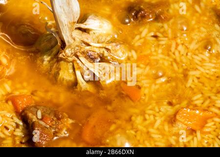 Step by step Cooking tasty pilaf. Rice added to Zirvak in a cauldron. Traditional pilaf cooking Stock Photo