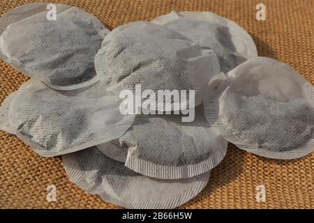 Close up of round perforated tea bags on a hessian sack background Stock Photo