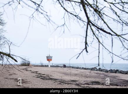 10 March 2020, Schleswig-Holstein, Lübeck-Travemünde: Two walkers are on the almost deserted beach at the water of the Baltic Sea. Photo: Daniel Bockwoldt/dpa Stock Photo