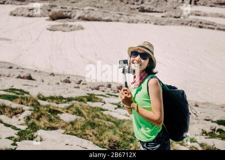 Woman traveler in summer mountains, video blogger concept Stock Photo