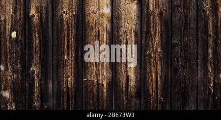Rustic old wood background, dark wooden texture, wide panoramic banner. Natural weathered fence with nails. Brown planks timber floor Stock Photo