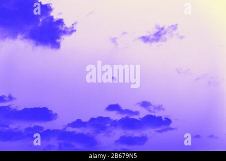 Moon behind the clouds, violet blue toned Stock Photo