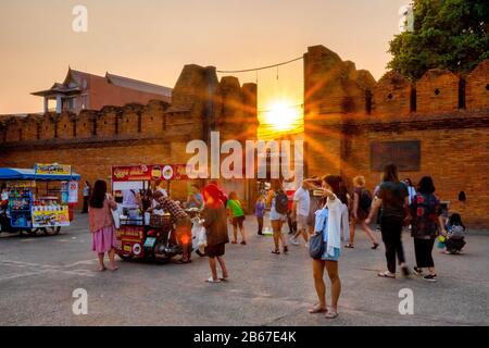 A tourist posing for a selfie in front of the Tha Phae gate at sunset, Chiang Mai, Thailand Stock Photo