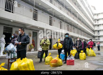 Wuhan, China. 10th Mar 2020. Cured coronavirus patients line up to leave a rehabilitation center after a 14-day quarantine for medical observation in Wuhan, central China's Hubei Province, March 10, 2020. A total of 143 cured coronavirus patients who were discharged from hospital finished their 14-day quarantine for medical observation on Tuesday at the rehabilitation center based in Wuhan Vocational College of Software and Engineering. Credit: Xinhua/Alamy Live News Stock Photo