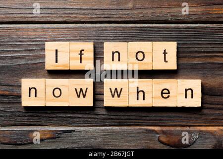 If not now when word written on wood block. If not now when text on wooden table for your desing, Top view concept. Stock Photo