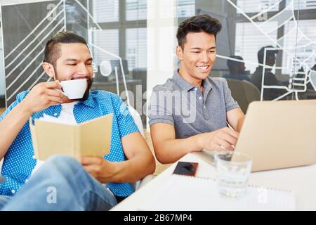 Two start-up programmers working on laptop computers in the office Stock Photo