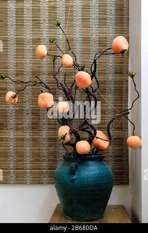 persimmon fruit on the tree in vintage pot Stock Photo