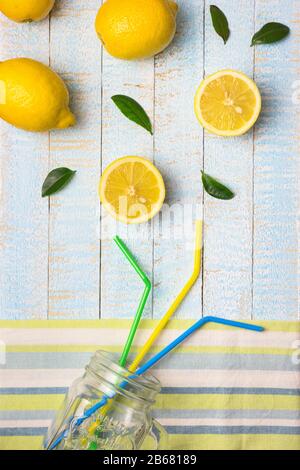 Flat lay composition with smoothie jar and fresh lemons on light blue wooden background. Copy space, top view. Stock Photo