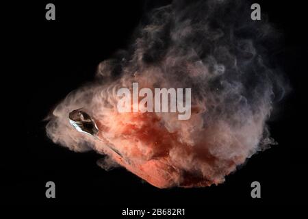 Bursting balloon full of coloured powder and glitter on a black background Stock Photo