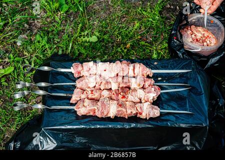 raw skewers are ready to be grilled outside in the garden. Stock Photo