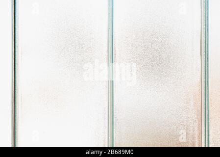 Old frosted patterned glass on a tiled window. Texture, transparent, matte white and grey frosted glass, blur effect Stock Photo