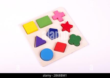 Wooden kindergarten shape puzzle game isolated on the white background Stock Photo