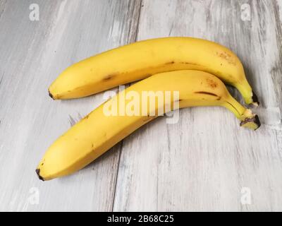 Two organic bananas close up on the reclaimed wood background Stock Photo