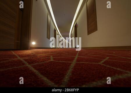 Empty luxury hotel coridor with red carpets, low angle Stock Photo