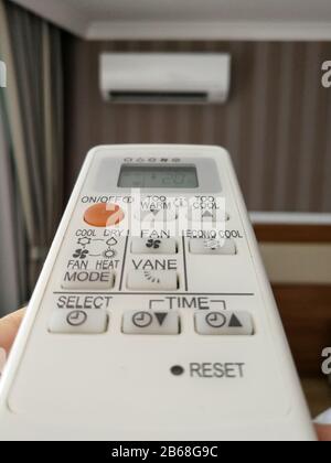 Remote control setting temperature for air conditioner on the wall Stock Photo