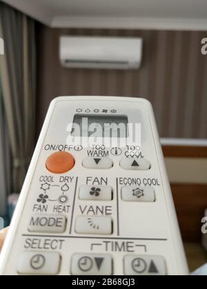 Remote control setting temperature for air conditioner on the wall Stock Photo
