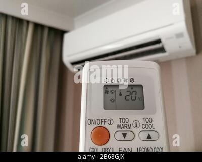 Remote control setting temperature for air conditioner on the wall Stock Photo