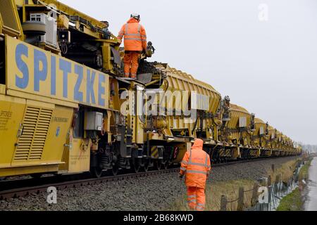 10 March 2020, Schleswig-Holstein, Südermarsch: With the help of a track-laying train, the ballast bed on the Marschbahn line between Husum and Friedrichstadt is being rehabilitated and the subgrade improved. This year, Deutsche Bahn plans to renew a total of around 52 kilometres of track and several points on the Marschbahn line between Hamburg and Westerland on Sylt. The investment sum amounts to 50.7 million euros. Photo: Carsten Rehder/dpa Stock Photo