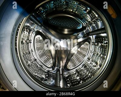 Washing machine drum with many holes internal view Stock Photo
