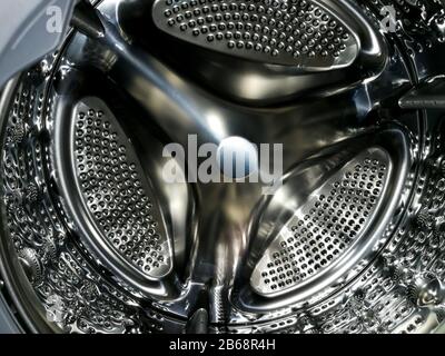 Washing machine drum with many holes internal view Stock Photo