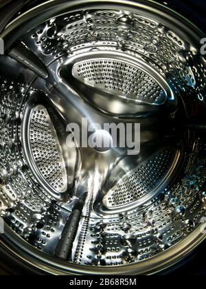 Washing machine drum with many holes internal view Stock Photo