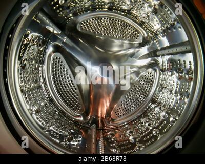Washing machine drum with many holes internal view Stock Photo