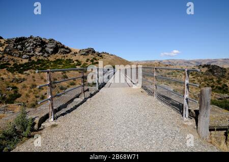 The Central Otago Rail Trail crosses a bridge over a gorge near the township of Lauder. The Trail is a multi day cycle ride or hike. Stock Photo