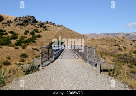 The Central Otago Rail Trail crosses a bridge over a gorge near the township of Lauder. The Trail is a multi day cycle ride or hike. Stock Photo