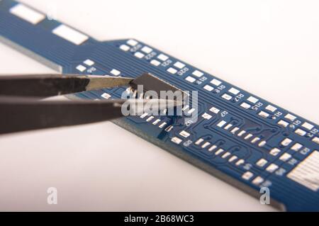 Small electronics integrated circuit IC on empty printed circuit board ready for hand assembly Stock Photo